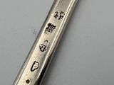 a silver spoon with a design on it sitting on a table