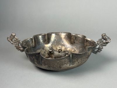 silver plated bowl with handles and handles on a gray surface
