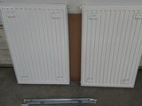 pair of white radiators on a floor next to a wall