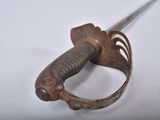 a small metal object with a long handle on a white surface