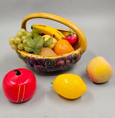 a bowl of fruit and two lemons next to each other