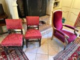 four chairs in a room with a fireplace and a rug on the floor