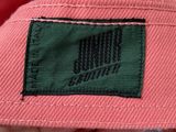 someone is holding a pink hat with a black label on it
