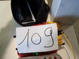 a small electronic device sitting on a table next to a bag
