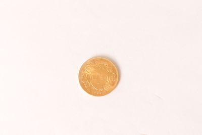 a gold coin sitting on top of a white surface