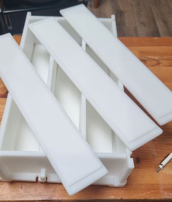 a wooden table with a bunch of white trays on top of it