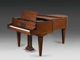 un vieux piano avec un meuble en bois posé sur une table
