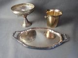 two silver dishes and a silver cup on a table