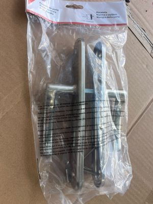 deux pièces métalliques se trouvent dans un emballage posé sur une boîte en carton