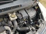 the engine of a car with its hood open on the side of the road