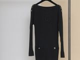 a black sweater dress hanging on a hanger in a room