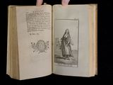 a hand holding an open book with a drawing on it
