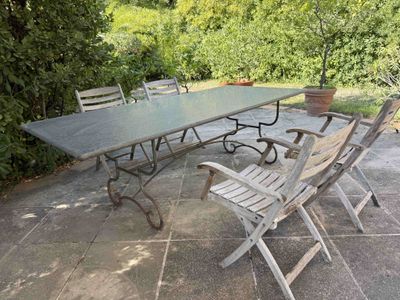 a table and chairs on a patio with trees in the background