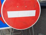 a red and white sign with an arrow on it next to a blue and white sign with an arrow on it