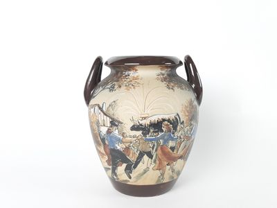 a vase with a painting on it sitting on a table