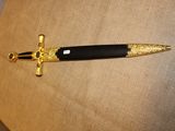 un stylo noir et doré orné d'une croix dorée