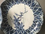 two blue and white plates with designs on them