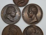 quatre pièces de bronze représentant des visages sur un fond blanc