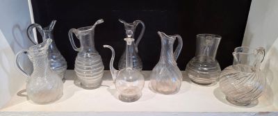 de nombreux vases en verre posés sur une étagère