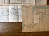 Plusieurs vieilles cartes du monde sont étalées sur une table