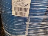 un tonneau bleu recouvert de plastique, posé sur l'herbe