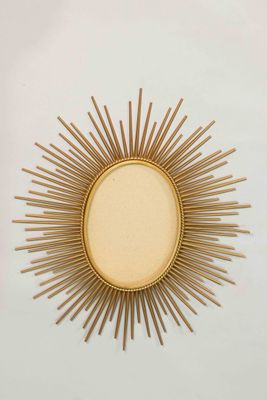 a close up of a gold sunburst on a white wall