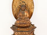 an image of a statue of a buddha sitting on top of a pile of books