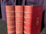 trois livres rouges superposés sur une table