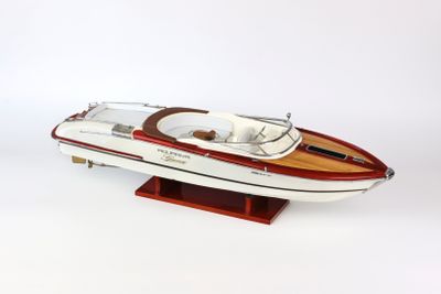 une maquette de bateau posée sur un socle, sur une surface blanche