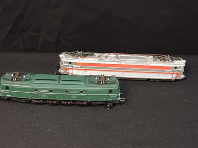 two toy trains sitting side by side on a black surface