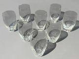 six verres vides posés sur une table, avec une ombre