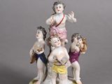 a figurine of a group of children on a pedestal