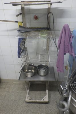a kitchen with a stove and a rack with pots and pans on it