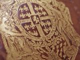 an old book with a gold emblem on it sitting on a table