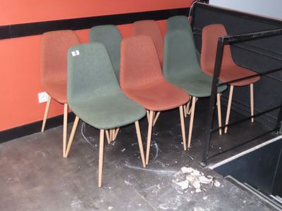 Plusieurs chaises sont alignées contre un mur dans une pièce