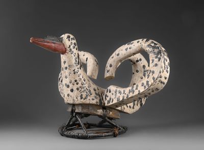 une sculpture en noir et blanc représentant un oiseau, posée sur un socle
