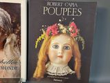 three books on a table, one of which is a doll and the other of which is a doll