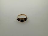 a close up of a gold ring with a black stone