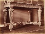 une vieille photo d'une table très ouvragée au milieu d'une pièce