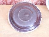 a brown plate sitting on a table next to a bowl