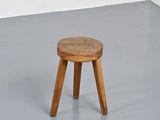 a small wooden stool sitting on top of a cement floor