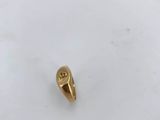 a gold ring with a skull on it sitting on top of a white surface