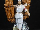 figurine représentant un homme tenant un fagot de bûches sur fond noir
