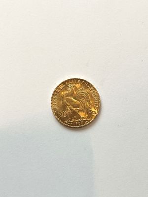 a close up of a gold coin on a white surface
