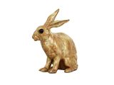 une petite statue représentant un lapin assis sur une surface blanche