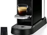 un gros plan d'une machine à café avec une tasse de café à côté