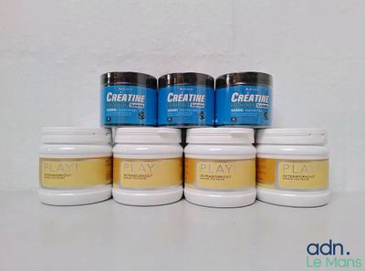 quatre pots de créatine posés les uns à côté des autres sur une table