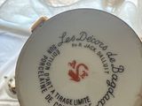 someone is holding a white plate with a red and black design on it
