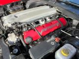 a red car engine with the hood up and the hood down