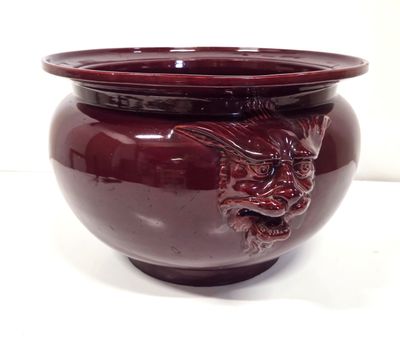 a red vase with a dragon on it on a white surface